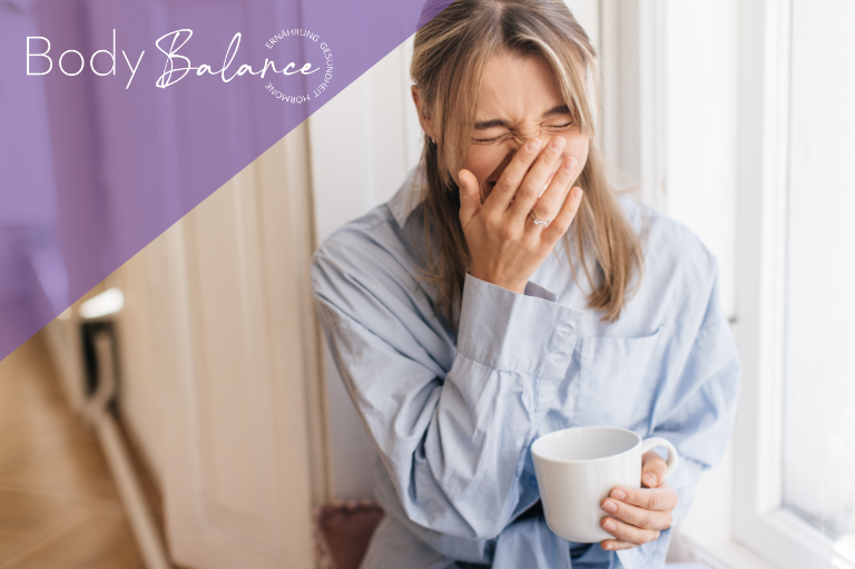 Müdigkeit durch Hormone – erschöpfte Person mit Kaffeetasse